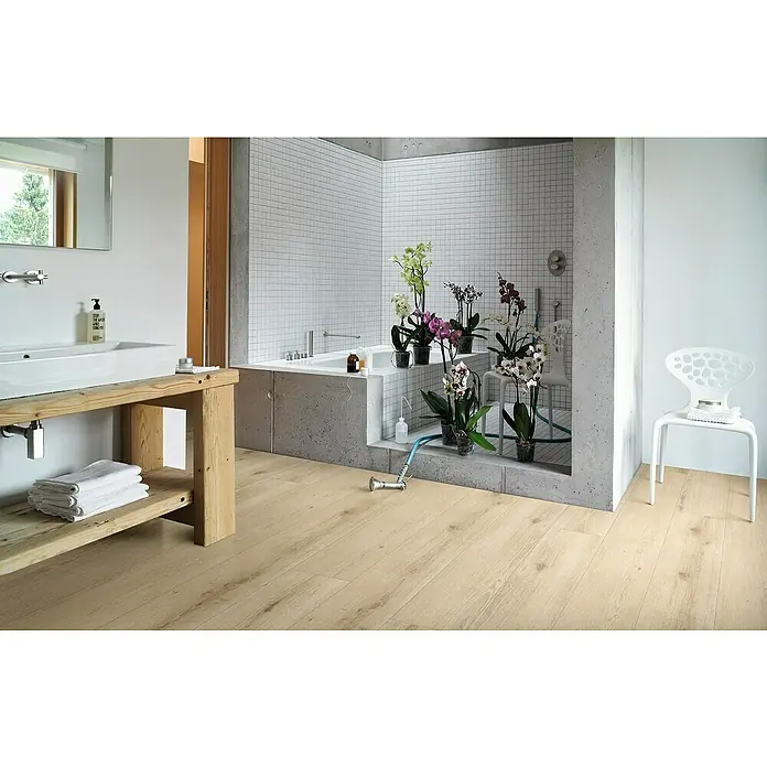 Parador Designbodenmuster Modular ONE Eiche Urban hell - 200 x 235 x 8 mm, Landhausdiele - Das Badezimmer verfügt über einen hellen Holzboden, eine Badewanne mit Betonumrandung und weißen Fliesen sowie ein Waschbecken mit Holzunterschrank.