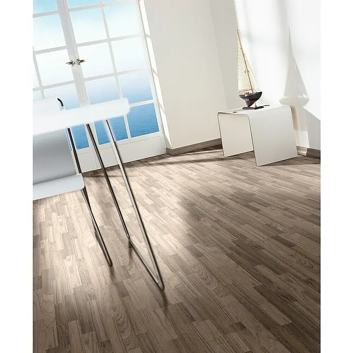 Parador Laminatmuster Basic 400 Ozean Teak - 200 x 194 x 8 mm, Schiffsboden - Ein helles Interieur mit Holzboden, einem weißen Tisch und einem maritimen Deko-Boot, das eine entspannte und stilvolle Atmosphäre vermittelt.