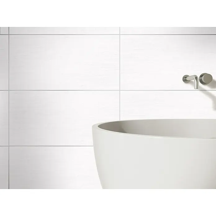 Wandfliese Eifel New - 30 x 60 cm, Weiß, Matt - Ein Badezimmer mit einer freistehenden Badewanne, weißen Fliesen und einem modernen Wasserhahn. Die Badewanne ist das zentrale Element des Bildes.