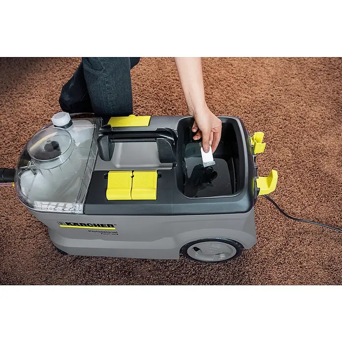 Kärcher Teppichreiniger Tabs RM 760 - 16 Stk. - Ein Kärcher Professional Puzzi 10/2 Teppichreinigungsgerät wird mit einer Reinigungstablette befüllt, um Teppiche effektiv zu säubern.