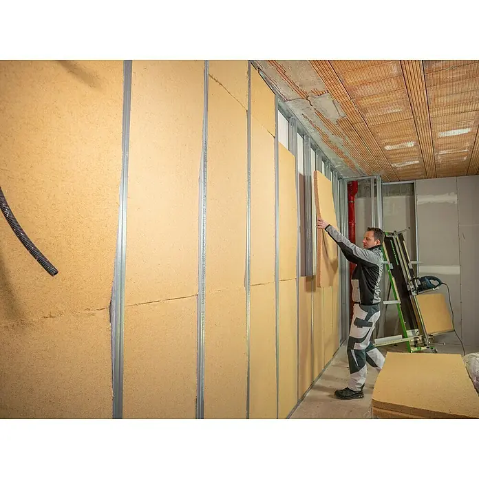 Steico Holzfaserdämmplatte flex 0381.200 x 625 mm, Stärke: 60 mm, Wärmeleitfähigkeit: 0,038 W/(mK), 7 Stk. - Der Handwerker montiert Holzfaserplatten zur Wanddämmung in einem Innenraum. Nachhaltige Bauweise für besseren Schall- und Wärmeschutz.