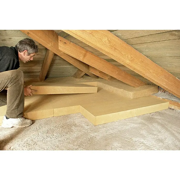 Steico Holzfaserdämmplatte top1.200 x 400 mm, Stärke: 80 mm, Wärmeleitfähigkeit: 0,04 W/(mK) - Ein Mann verlegt Dämmplatten auf dem Dachboden, um das Haus zu isolieren und Energie zu sparen. Effektive Isolierung für verbesserten Wohnkomfort.