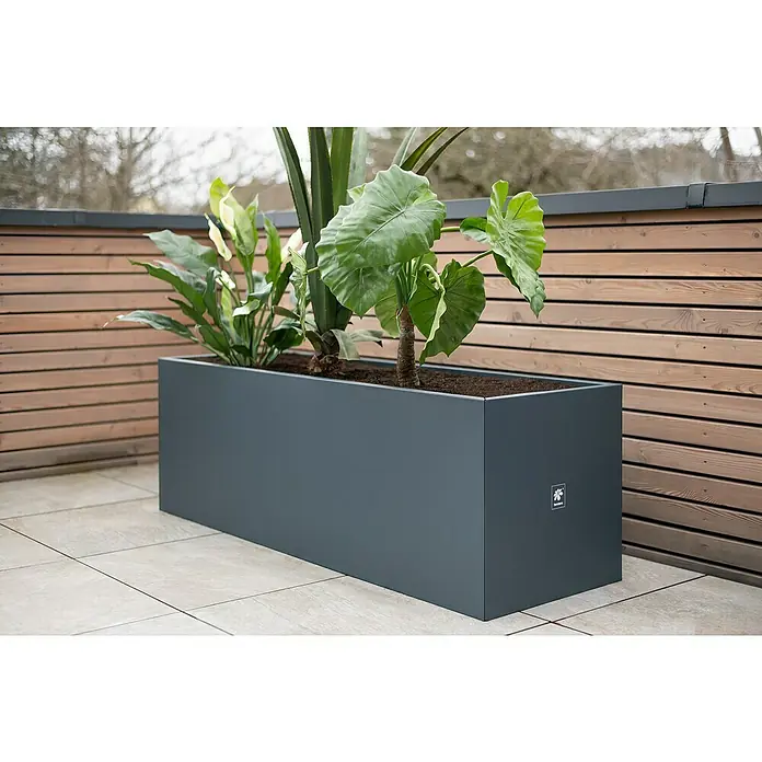 Herstera Garden Pflanzkasten Cube - Außenmaß (L x B x H): 150 x 50 x 50 cm, Metall, Anthrazit - Großer, rechteckiger, anthrazitfarbener Pflanzkasten aus Metall mit verschiedenen Pflanzen auf einer Terrasse.