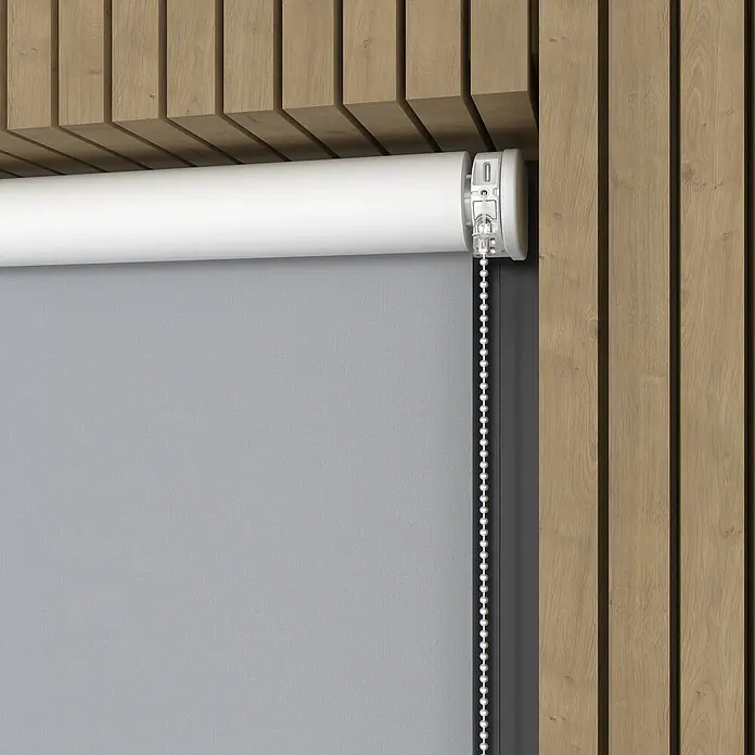 Verdunkelungsrollo Elektrisch - B x H: 160 x 190 cm, Hellgrau, Uni - Detailansicht einer grauen Rollmarkise mit weißer Rollstange und Kettenzug vor einer Holzwand. Praktischer Sonnenschutz für Ihr Zuhause!