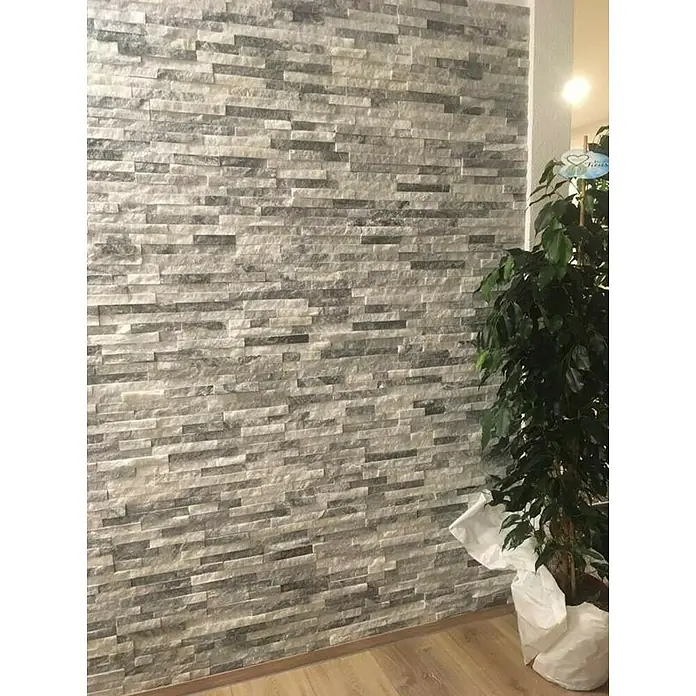 Verblendstein Nature - 10 x 40 cm, Weiß/Grau, Natursteinoptik - Wandverkleidung mit grauen Steinen, die eine moderne und stilvolle Ästhetik verleihen. Das Muster erzeugt eine elegante Textur an der Wand.