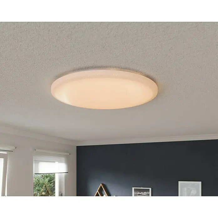 Tween Light LED-Deckenleuchte rund Skyler Star Big - 85 W, Ø x H: 90 x 10 cm, Weiß, Mehrfarbig - Nahaufnahme einer runden, weißen LED-Deckenleuchte, die an einer weißen Decke montiert ist und ein warmes Licht ausstrahlt.
