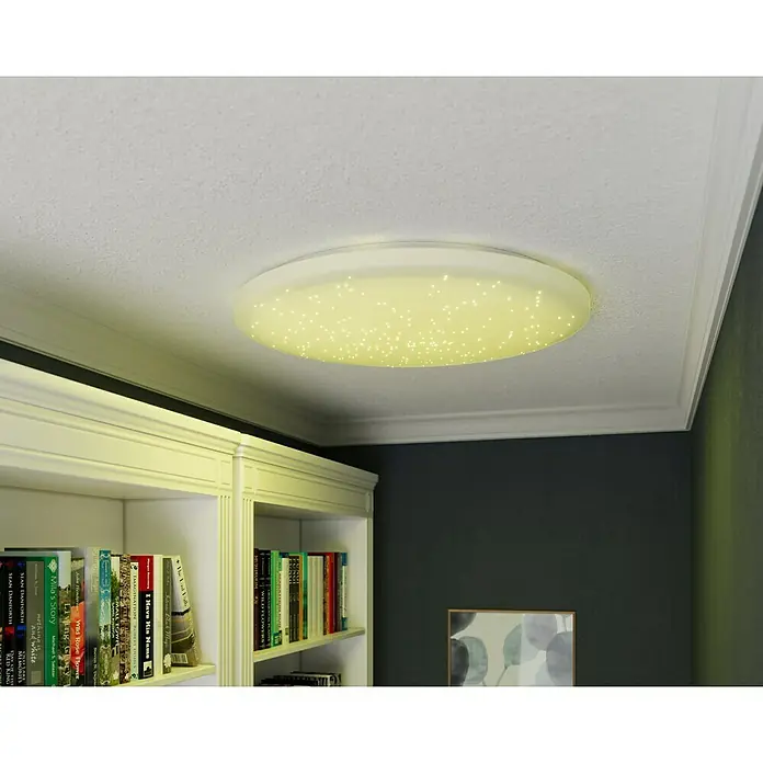 Tween Light LED-Deckenleuchte rund Skyler Star RGBW - 80 W, Ø x H: 74 x 10 cm, Weiß, RGBW - Nahaufnahme einer modernen LED-Deckenleuchte mit Sternenhimmel-Effekt, die ein warmes, einladendes Licht in einem stilvollen Raum ausstrahlt.