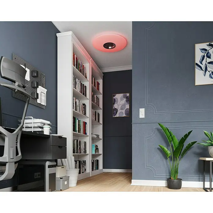 Tween Light LED-Deckenleuchte rund - 24 W, Weiß, RGBW - Das Bild zeigt eine moderne Büroumgebung mit einem stilvollen Bücherregal und einer auffälligen roten Deckenleuchte, die den Raum akzentuiert.