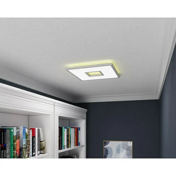 LED-Deckenleuchte Ellia - 24 W, L x B x H: 45 x 45 x 5 cm, Weiß, RGB - Deckenleuchte mit quadratischem Design und sanfter Beleuchtung, montiert an einer strukturierten weißen Decke über einem Bücherregal.