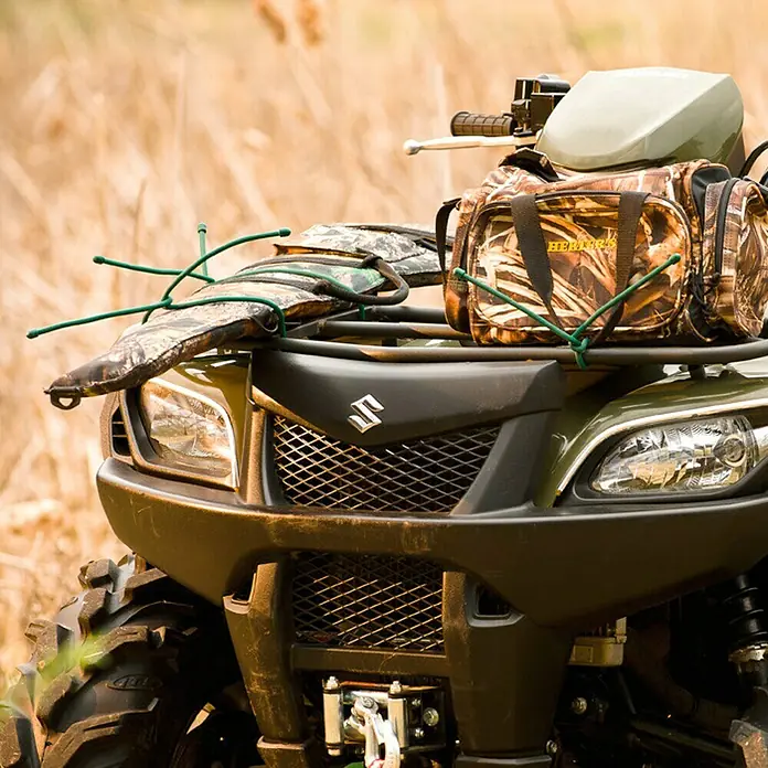 Nite Ize Set de bridas para cables Gear Tie - Otros, Negro - Un ATV Suzuki verde oliva con equipamiento de camuflaje. Perfecto para la caza o aventuras todoterreno.