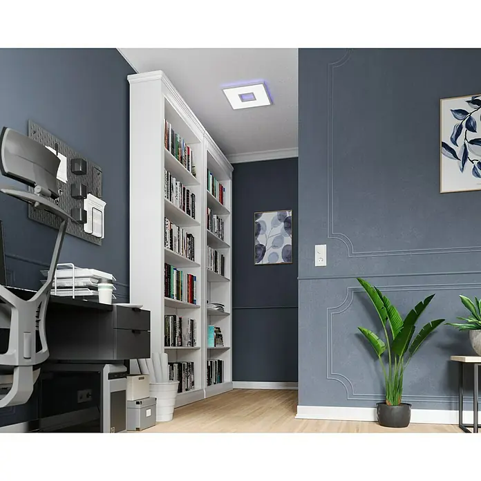 LED-Deckenleuchte Ellia - 24 W, L x B x H: 45 x 45 x 5 cm, Weiß, RGB - Bücherregal im Arbeitszimmer. Das Bücherregal ist weiß und voll mit Büchern. Das Zimmer ist modern eingerichtet.