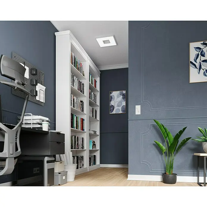 LED-Deckenleuchte Ellia - 24 W, L x B x H: 45 x 45 x 5 cm, Weiß, RGB - Weißes Bücherregal gefüllt mit Büchern in einem blauen Raum mit Schreibtisch und Zimmerpflanze.