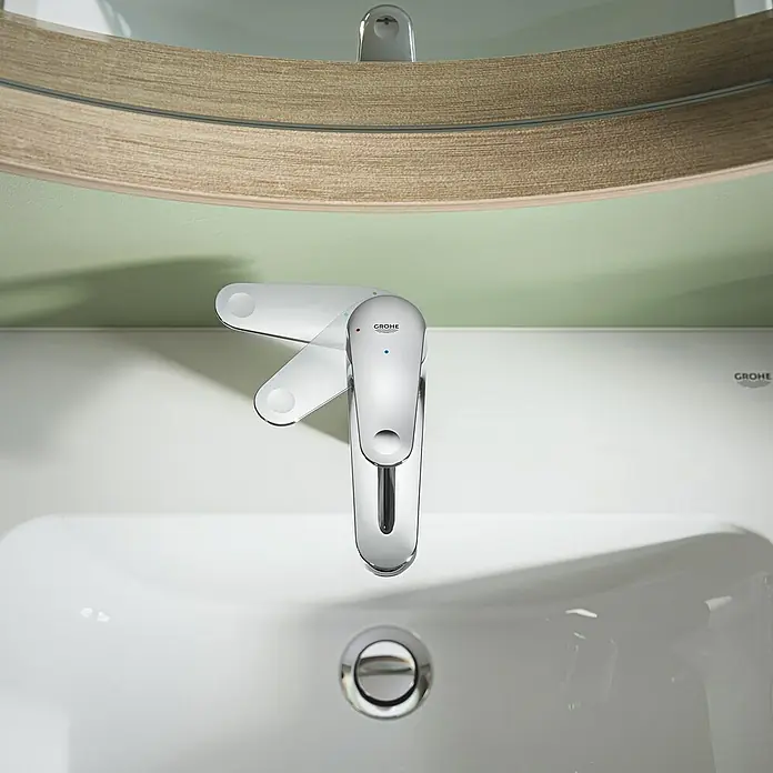 Grohe QuickFix Grifo de lavabo Swift S - Cromo, Brillante - Primer plano de un grifo Grohe con caño giratorio sobre un lavabo con espejo en el baño.