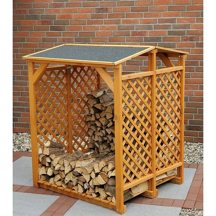 Promadino Kaminholzregal - 120 x 118 x 148 cm, Holz, Braun - Holzschuppen mit Lattenmuster und Dach, gefüllt mit Brennholz, steht vor einer roten Backsteinmauer.