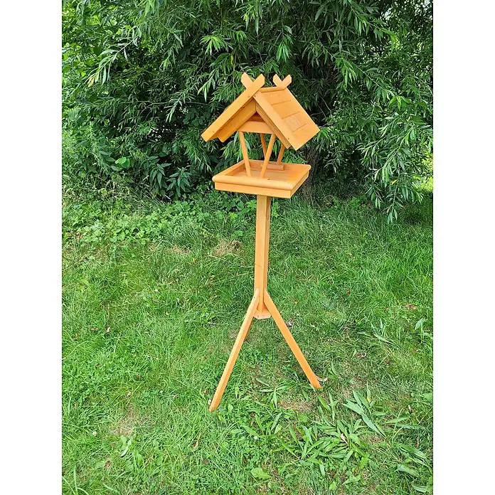 Promadino Vogelhaus Rhön - 42 x 36 x 38 cm, Holz, Braun, Ausstattung: Vogelhausständer - Ein hölzernes Vogelhaus auf einem Ständer im Garten, umgeben von Grün. Perfekt für Vogelliebhaber und Gartenfreunde.
