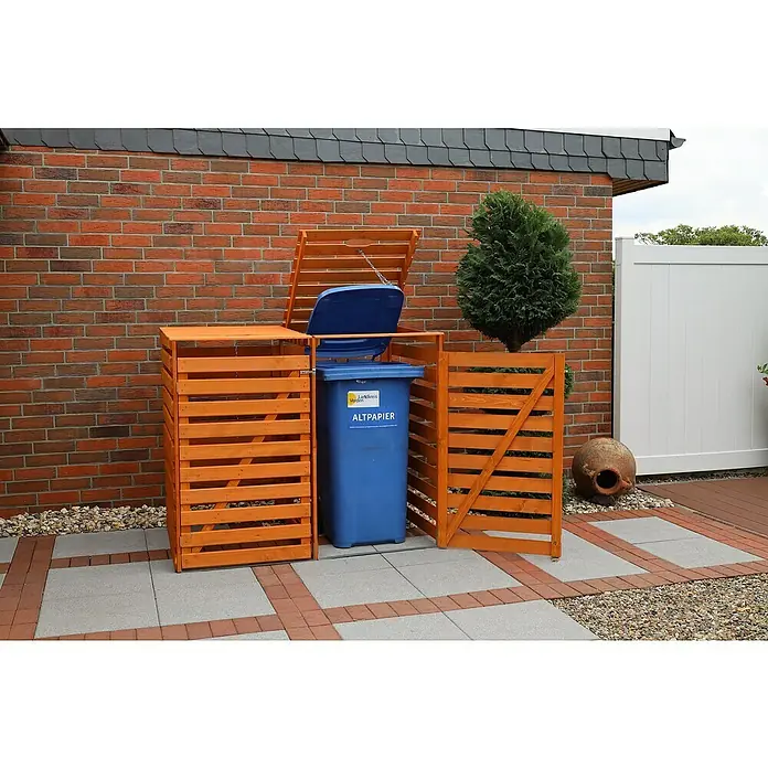 Promadino Mülltonnenbox Variov -  - Das Bild zeigt eine blaue Altpapiertonne, die sich in einer hölzernen, orangefarbenen Mülltonnenbox im Freien befindet.