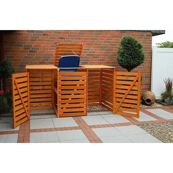 Promadino Mülltonnenbox Variov -  - Diese Aufnahme zeigt eine hölzerne Mülltonnenbox mit Mülltonne auf einer gepflasterten Fläche vor einer Backsteinmauer.