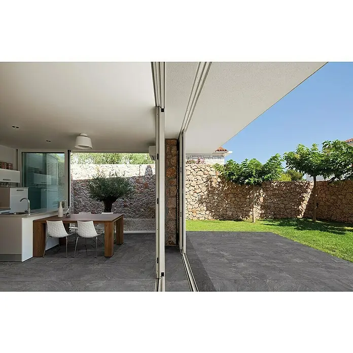Momastela Feinsteinzeugfliese 2.0 Concept - 60 x 60 cm, Anthrazit - Das Bild zeigt eine moderne Terrasse mit großformatigen Fliesen, die Innen- und Außenbereich verbinden und ein stilvolles Ambiente schaffen.