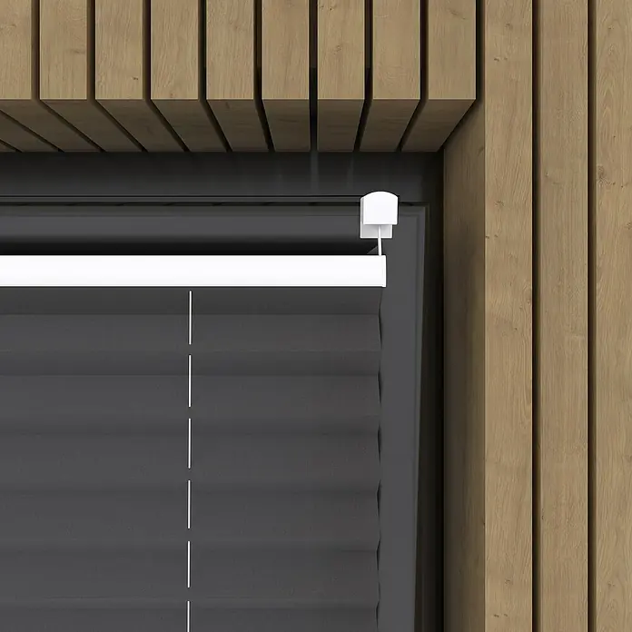 Plissee Basic VS Thermo - B x H: 75 x 130 cm, Anthrazit, Verdunkelnd - Nahaufnahme einer grauen Fensterjalousie mit weißem Rahmen vor einer Holzwand, die ein modernes und stilvolles Designelement zeigt.