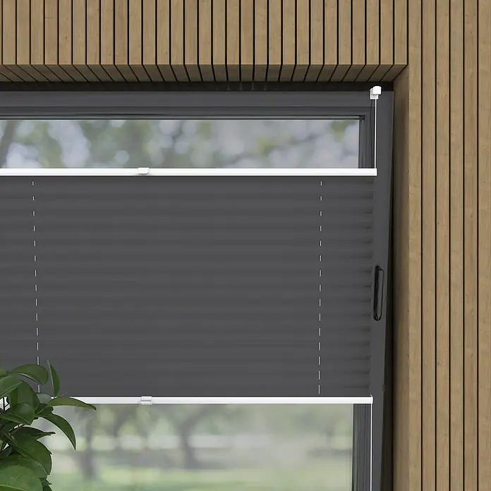 Plissee Basic VS Thermo - B x H: 75 x 130 cm, Anthrazit, Verdunkelnd - Nahaufnahme eines grauen Faltstores am Fenster, der das Licht reguliert und Privatsphäre bietet, eingebettet in eine Holzverkleidung.