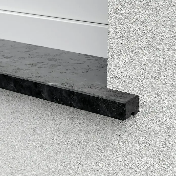 Fensterbank Steel Grey Reptil - 151 x 25 x 2 cm, Anthrazit, Naturstein - Nahaufnahme einer Fensterbank aus dunklem Stein, die architektonische Details und Texturen hervorhebt.