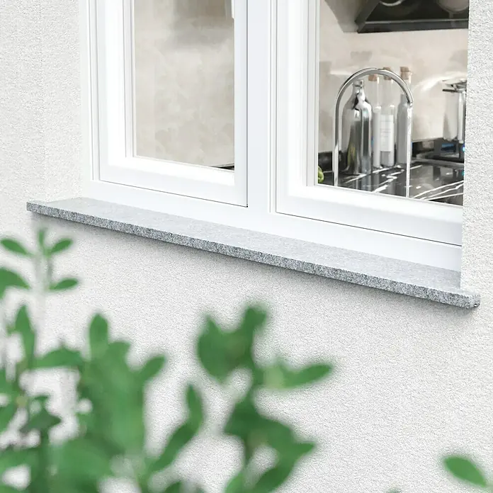 Fensterbank Bianco Cordo - 101 x 25 x 2 cm, Grau, Naturstein - Nahaufnahme einer Fensterbank aus Granit unter einem weißen Fenster, die eine elegante und robuste Ergänzung für jedes Zuhause darstellt.