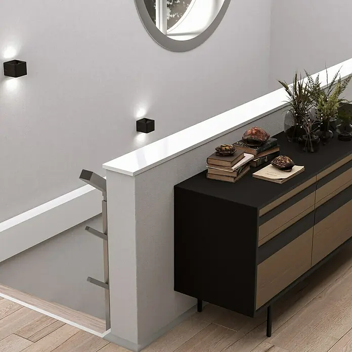 Fensterbank Snow White Micro - 113 x 30 x 2 cm, Weiß, Kunststein, Agglo-Marmor - Innenaufnahme eines stilvollen Sideboards mit Dekorationsgegenständen wie Büchern und Vasen, beleuchtet durch moderne Wandleuchten.