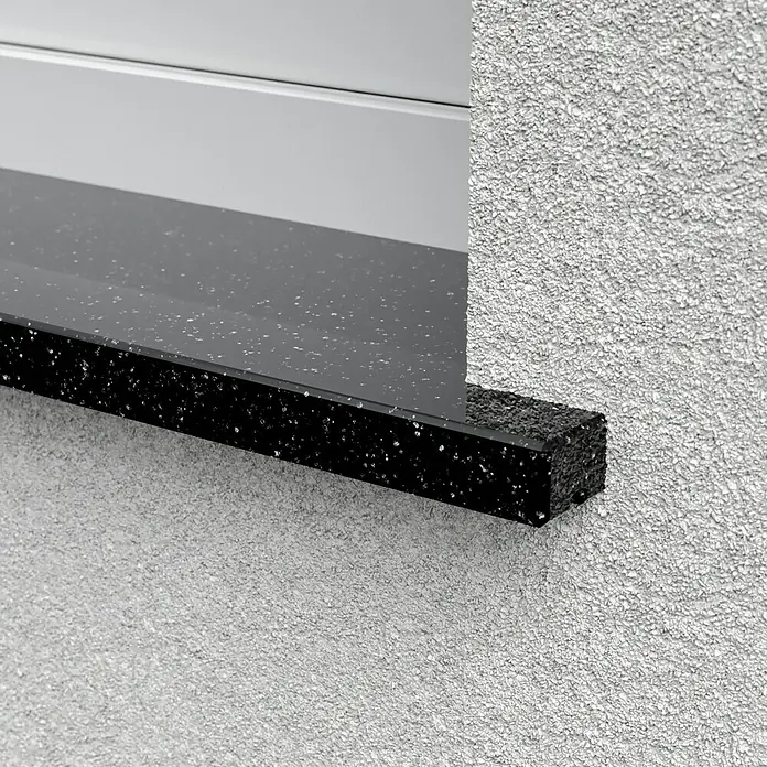 Fensterbank Star Galaxy113 x 30 x 2 cm, Schwarz, Naturstein - Nahaufnahme einer Fensterbank aus schwarzem Polymerbeton, die nahtlos in eine Fassade übergeht. Strukturierte Oberfläche.