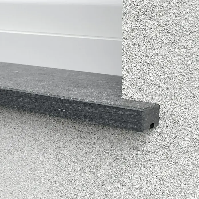 Fensterbank Fossil Riff - 113 x 30 x 2 cm, Anthrazit, Naturstein - Nahaufnahme einer Fensterbank aus dunklem Stein mit rustikaler Fassade, die eine stilvolle und dauerhafte Ergänzung für jedes Gebäude darstellt.