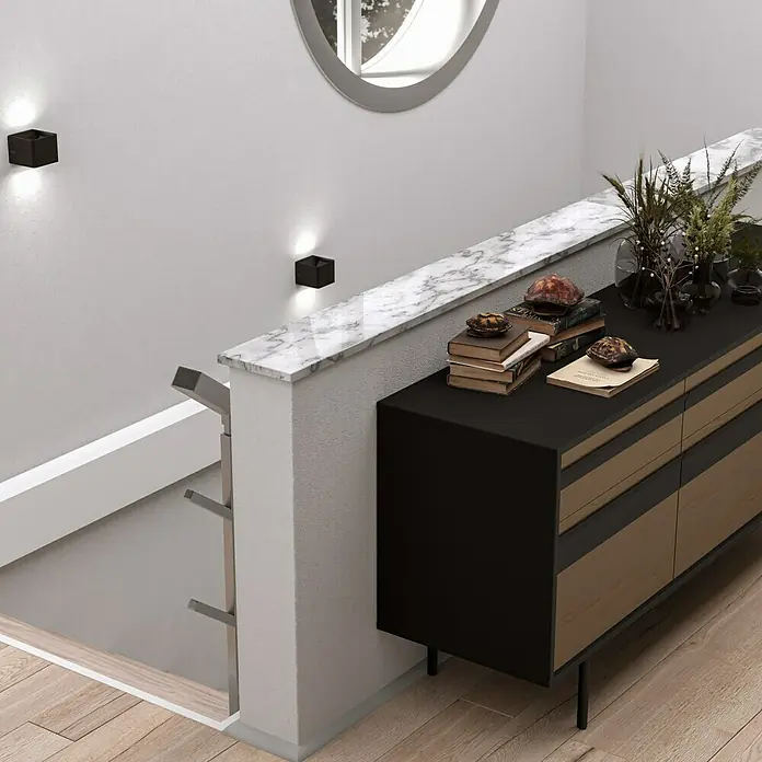 Fensterbank Mountain White Micro - 151 x 25 x 2 cm, Weiß, Kunststein, Agglo-Marmor - Ein modernes Sideboard in Schwarz und Holz mit Dekorationen auf einer Marmorplatte neben einem Treppenabgang.