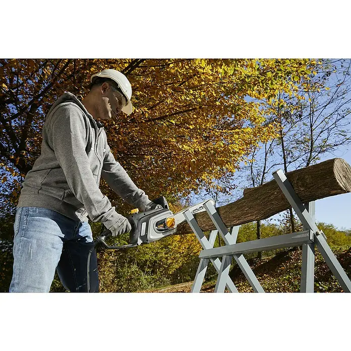 Alpina Elektro-Kettensäge ACS 180 E - 1.800 W, Schwertlänge: 35 cm - Ein Mann sägt mit einer Alpina Kettensäge ein Holzstück, welches auf einem Sägebock liegt, umgeben von herbstlichen Bäumen.