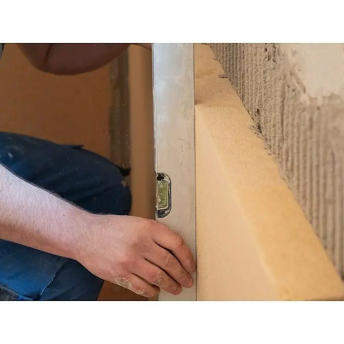 Steico Holzfaserdämmplatte internal1.200 x 380 mm, Stärke: 40 mm, Wärmeleitfähigkeit: 0,038 W/(mK) - Ein Handwerker überprüft mit einer Wasserwaage die Ausrichtung einer Dämmplatte an einer Wand, um eine korrekte Installation sicherzustellen.
