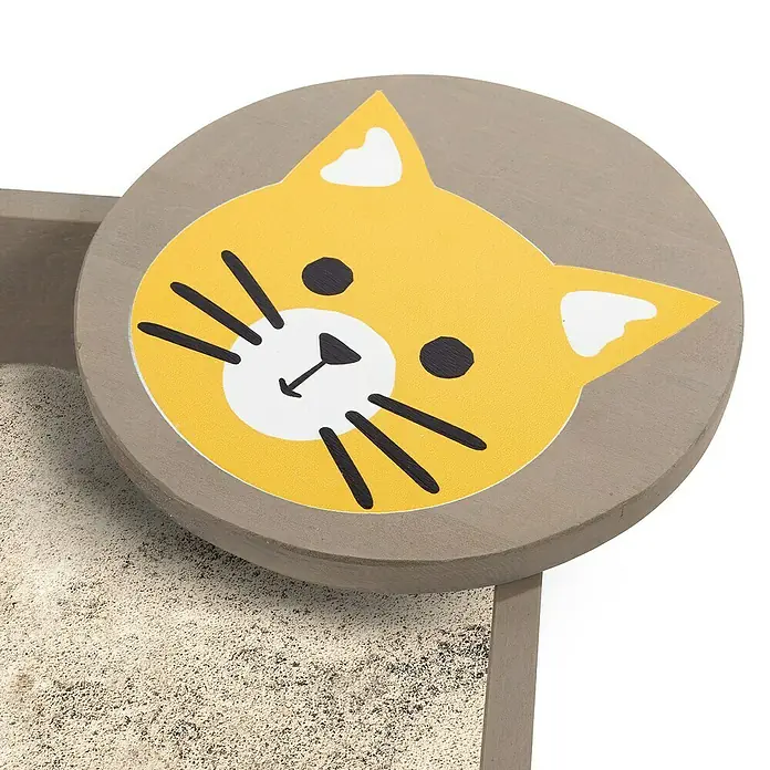 Muddy Buddy Sandkasten Wild Cat - 120 x 120 x 20 cm, Holz, Warmgrau/ Ocker - Nahaufnahme des Katzenstreu-Kästen mit einem gelben Katzengesicht auf einem grauen Deckel.