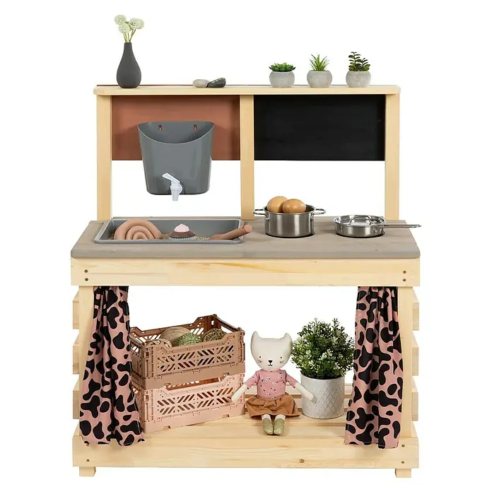 Muddy Buddy Matschküche Big Leo - 80 x 40 x 90 cm, Holz, Natur/ Puderrosa - Detailansicht einer Kinderspielküche aus Holz mit Zubehör wie Töpfen, Lebensmitteln und Vorhängen.