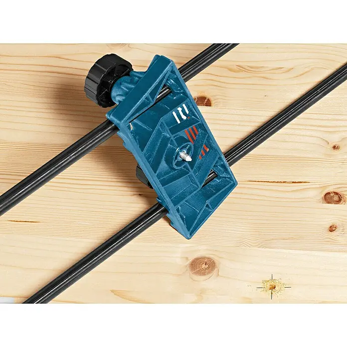 Bosch Professional Adapter OFZ - Passend für: Fräse und Schiene - Eine Bohrschablone für präzise Bohrungen in Holz. Das Werkzeug ist blau und schwarz und wird auf einem Holzbrett verwendet.