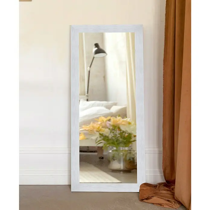 Espejo de pared XL - 78 x 178 cm, Blanco - Esta imagen muestra un espejo de cuerpo entero rectangular blanco apoyado contra una pared, que refleja una habitación con una cama y flores.