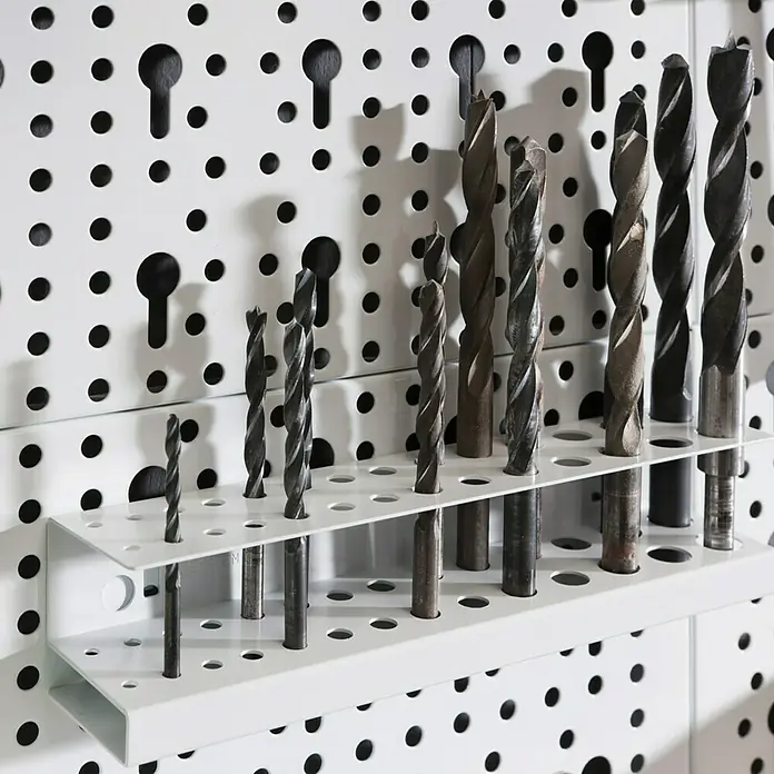 Element System Classic Lochwand-Set Organizer 1 - 2 x Stahllochplatten 80 x 20 cm, 2 x Wandschienen 50 cm, 18 verschiedene Werkzeughalter, Montagematerial, 28 -tlg. - Nahaufnahme einer Auswahl an Bohrern, die in einem weißen Halter an einer Lochwand befestigt sind, ideal für die Werkstattorganisation.