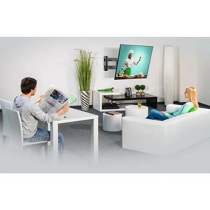 Hama TV-Wandhalterung schwenkbar - Passend für: Bildschirmdiagonale 32 - 65″, 81 - 165 cm, Belastbarkeit: 35 kg, Wandabstand: 5,8 cm - 52,1 cm - Ein Wohnzimmer mit einem schwenkbaren TV-Wandhalter, an dem ein Fernseher mit einer Kochsendung befestigt ist.