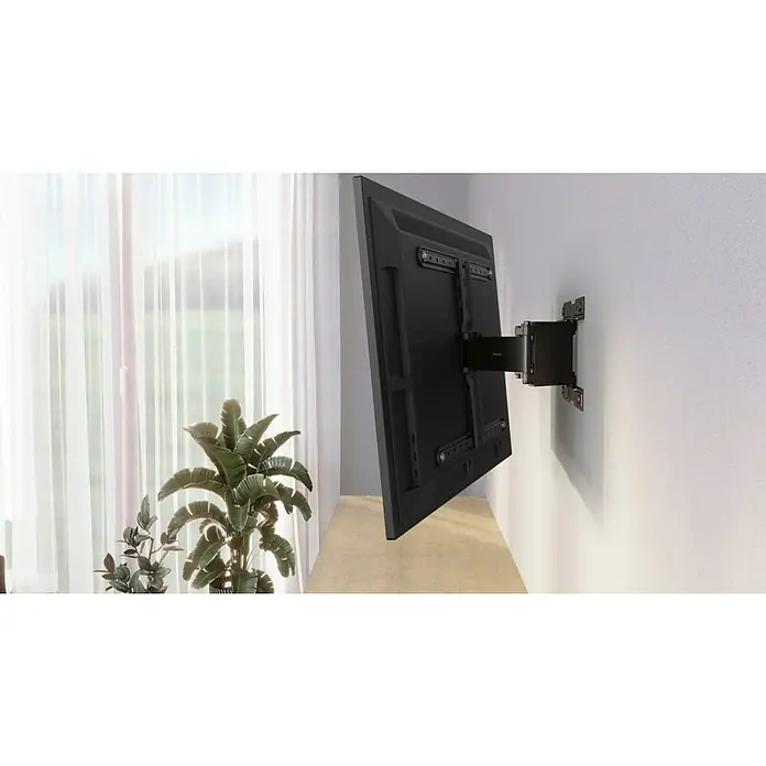 Hama TV-Wandhalterung schwenkbar Ultraslim - Passend für: Bildschirmdiagonale 37 - 90″, 94 - 228,6 cm, Belastbarkeit: 50 kg, Wandabstand: 2,3 cm - 27,8 cm - Ein schwenkbarer TV hängt an einer weißen Wand, neben einem Fenster mit Vorhängen und einer Zimmerpflanze. Der TV ist mit einer Halterung befestigt.