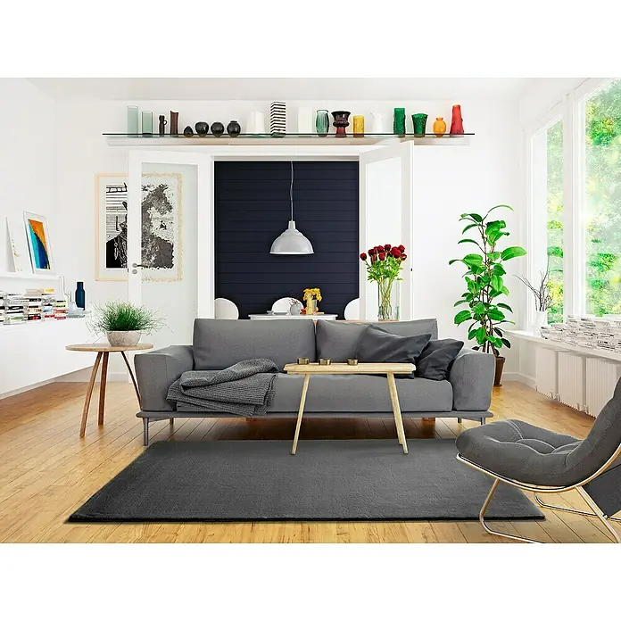 Alfombra de pelo corto Kristel - Gris, 110 x 60 cm, 100% Poliéster - Salón con sofá gris, alfombra y un sillón elegante. Un complemento ideal para un hogar moderno con un toque de estilo.