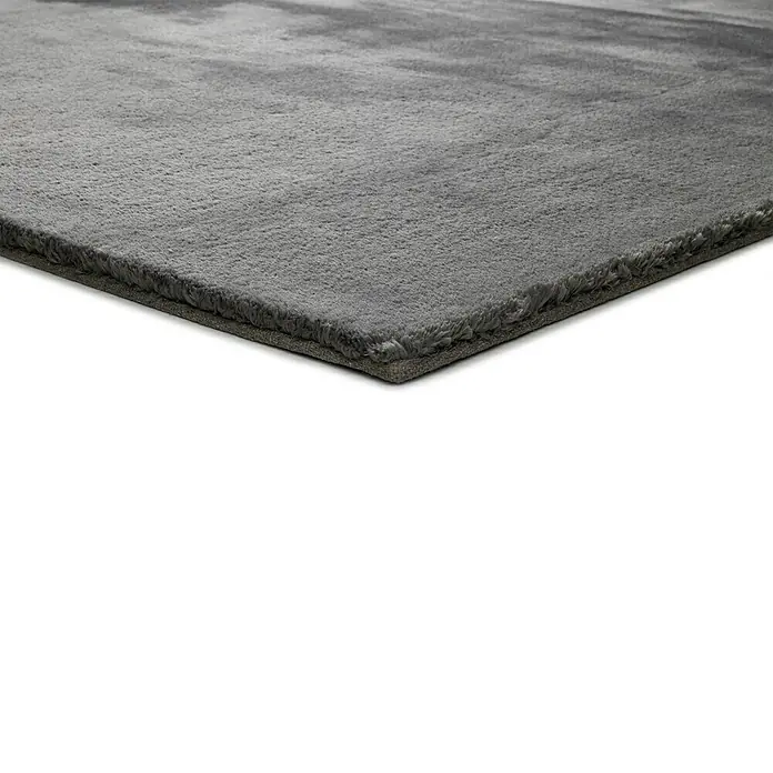 Alfombra de pelo corto Kristel - Gris, 110 x 60 cm, 100% Poliéster - Primer plano de una alfombra gris con textura suave, perfecta para añadir un toque acogedor. Ideal para salón o dormitorio.