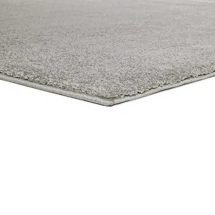 Alfombra de pelo corto Montana - Plata, 120 x 60 cm, 100% Polipropileno - Primer plano de una alfombra gris con textura suave y un borde limpio, ideal para un espacio habitable moderno.