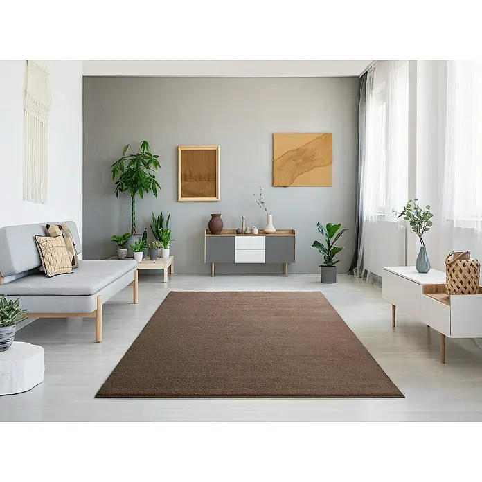 Alfombra de pelo corto Montana - Beige, 120 x 60 cm, 100% Polipropileno - Una acogedora sala de estar con una alfombra grande y marrón que irradia calidez y confort. La alfombra es el punto focal central de la habitación.