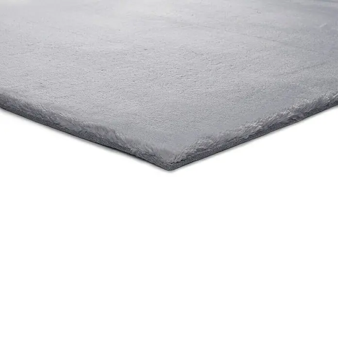 Alfombra de pelo corto Kristel - Plata, 110 x 60 cm, 100% Poliéster - Primer plano de una alfombra gris que muestra su textura suave. Esta alfombra añade confort y estilo a cualquier habitación. Perfecto para un ambiente acogedor.