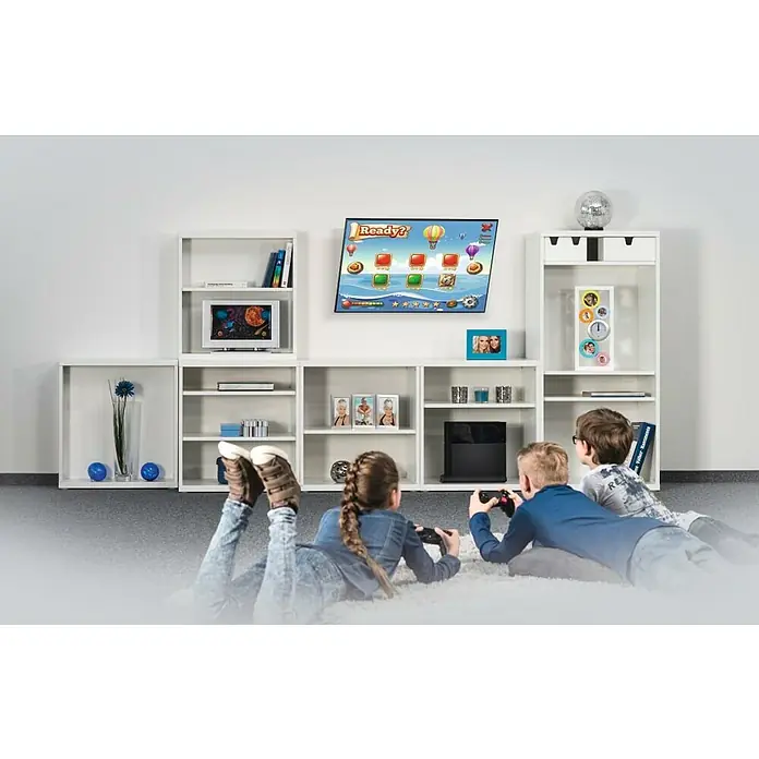 Hama TV-Wandhalterung neigbar - Passend für: Bildschirmdiagonale 32 - 75″, 81 - 191 cm, Belastbarkeit: 40 kg, Wandabstand: 2,8 cm - Drei Kinder liegen auf einem Teppich und spielen ein Videospiel auf einem Fernsehgerät, das an einer weißen Wand montiert ist.