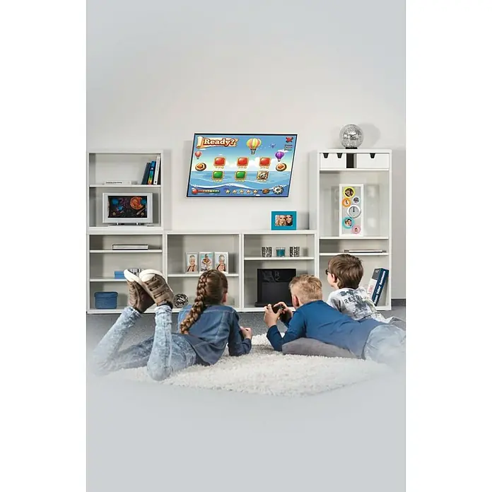 Hama TV-Wandhalterung neigbar - Passend für: Bildschirmdiagonale 32 - 75″, 81 - 191 cm, Belastbarkeit: 40 kg, Wandabstand: 2,8 cm - Kinder spielen Videospiele auf einem Teppich vor einem weißen Regal. Das TV-Gerät an der Wand zeigt ein Videospiel.