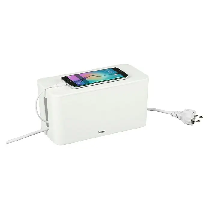 Hama Kabelbox Mini - Weiß - Weißer Hama Kabelmanager mit einem Smartphone obenauf, angeschlossen an ein Kabel, das in den Manager führt, und einem Stromkabel.