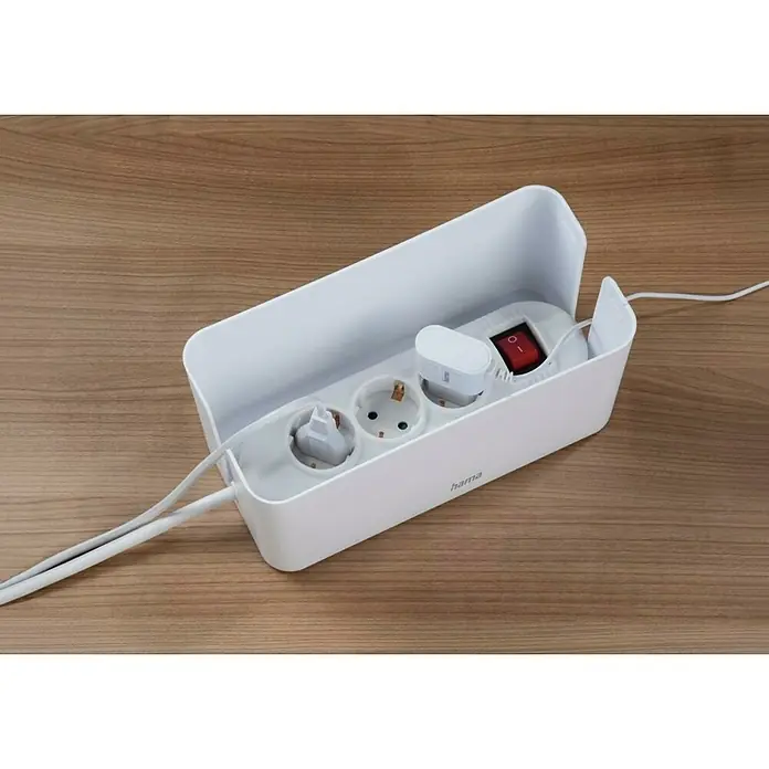 Hama Kabelbox Mini - Weiß - Eine weiße Hama-Kabelbox mit offenen Steckdosen, einem Stecker und einem roten Schalter auf einem Holztisch, die Ordnung und Sicherheit bietet.