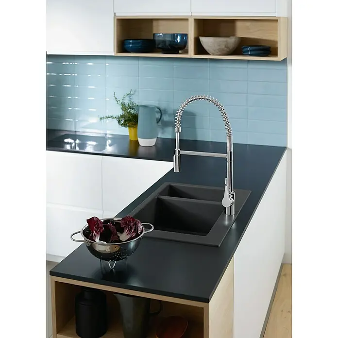 Hansgrohe Grifo de cocina Cento XXL - Cromo, Brillante - Fregadero de cocina con grifo y verduras. El fregadero está hecho de material oscuro y el grifo es de acero inoxidable. Las verduras están en un colador.