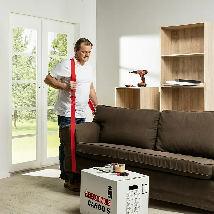 Möbel-Tragegurt - Länge: 4 m, Traglast: 60 kg - Ein Mann verwendet rote Tragegurte, um ein braunes Sofa zu bewegen, während eine Umzugskiste in der Nähe steht.